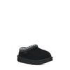 Black slipper with decorative trim on a white background