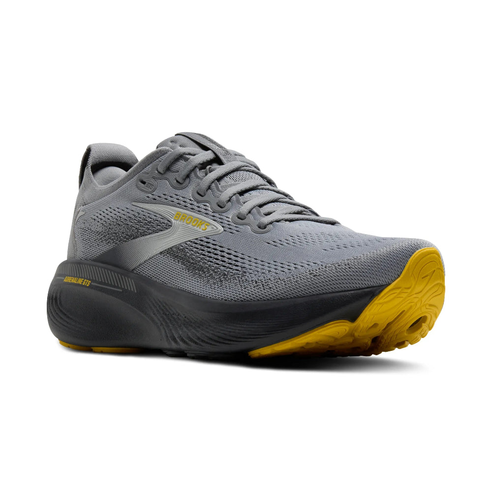 Gray athletic shoe with yellow sole on a white background