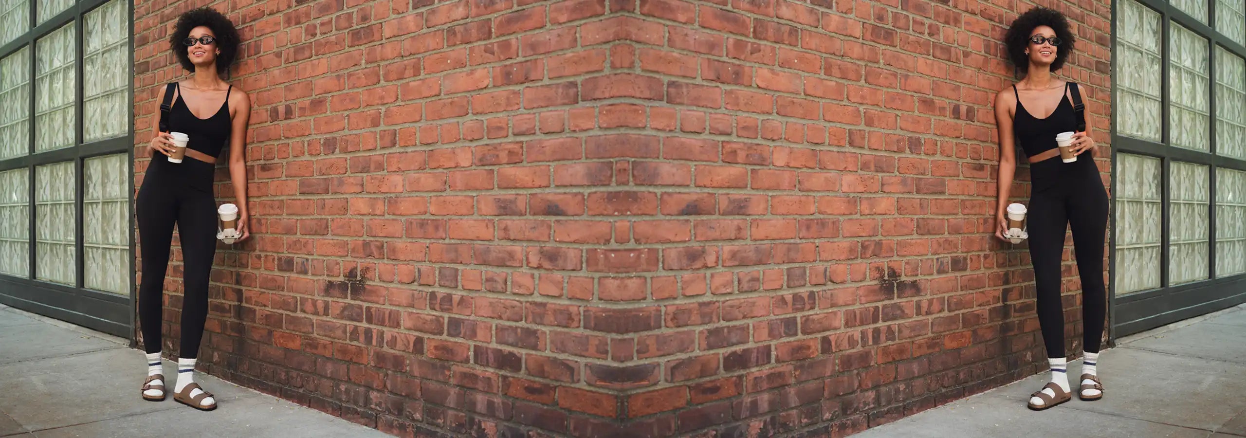 Woman standing against a brick wall in an urban setting