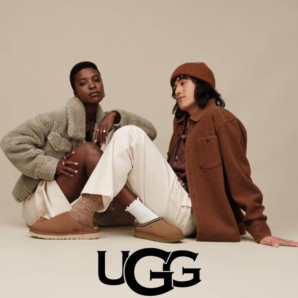 man and woman sitting wearing a pair of ugg shoes